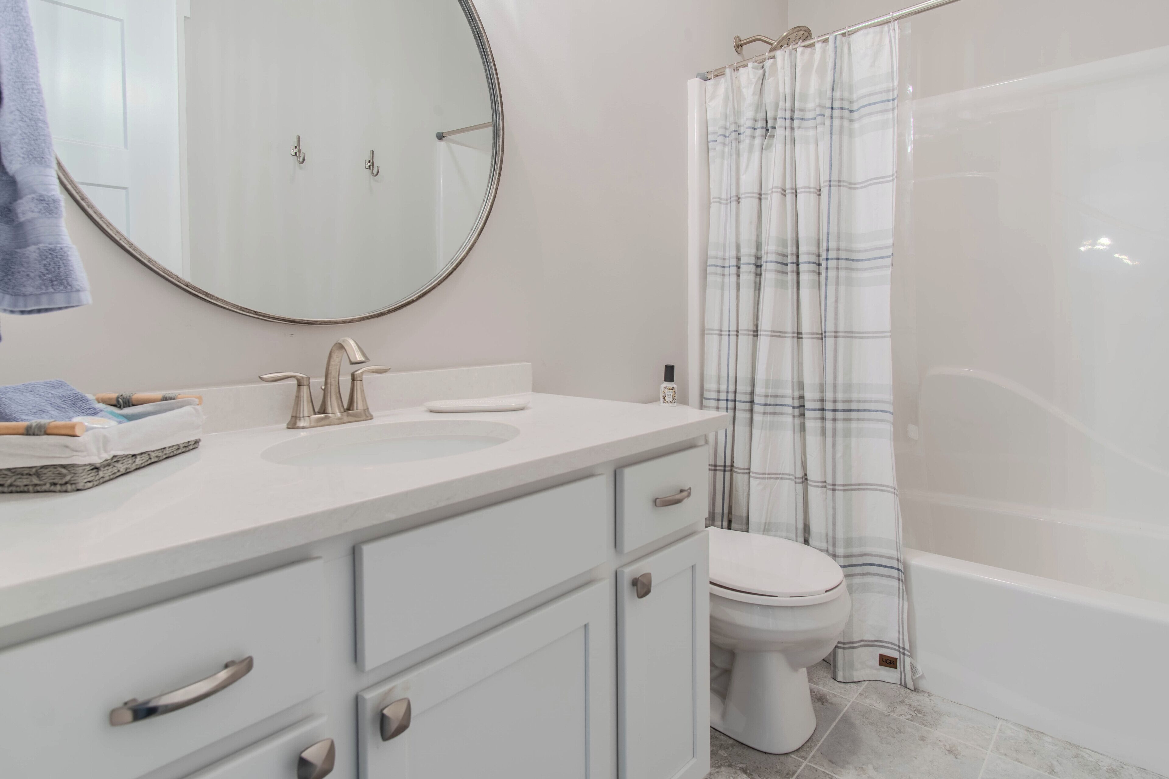 A bathroom with a white sink, mirror, and toilet.