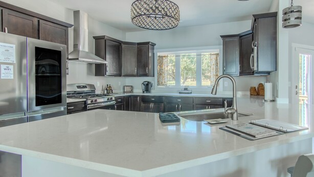 A modern kitchen with a large island, stainless steel appliances, and dark wood cabinets. - Modern Lakeside Retreat on Lake Ontario 4+ bedroom/3 bath (Dexter)