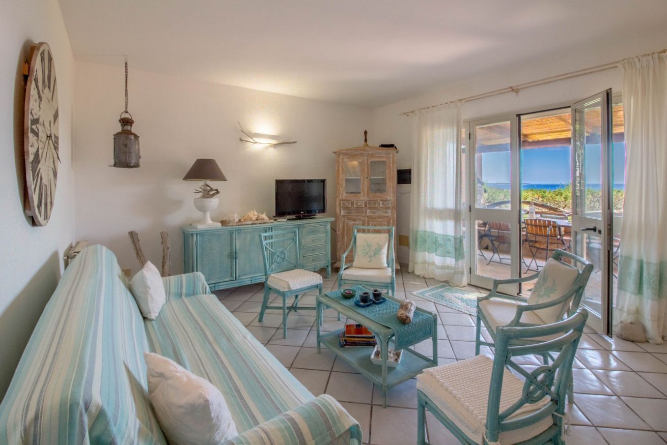 Un salon comprenant un canapé, des fauteuils, un téléviseur, un meuble et une vue sur l’extérieur.