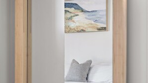 A bedroom with a bed, pillows, and a painting on the wall.