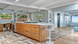 Una cocina moderna con armarios de madera, una isla central y vistas al exterior.