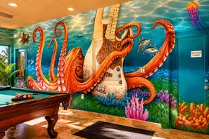 Un biliardo con un murale raffigurante un polpo sulla parete.