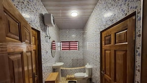 A narrow bathroom with a toilet, sink, and window. - Rankbel Holidays Apartment (Kumasi)