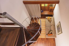 Una escalera de caracol conduce a una sala de estar con un sofá y cojines.
