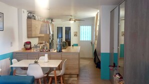 Eine kleine Küche mit Essbereich, Holzschränken und einem Deckenventilator.