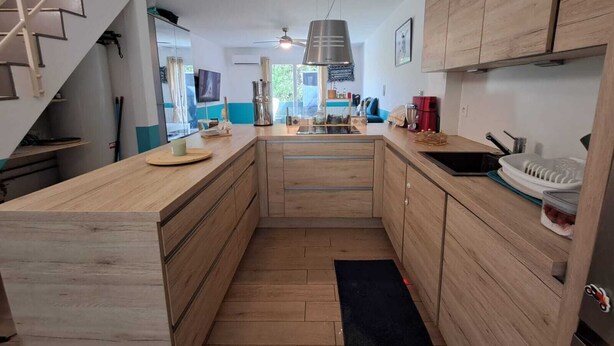Eine moderne Küche mit Holzschnitzereien, einer zentralen Kochinsel und einem Deckenventilator.