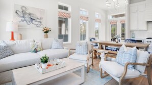 Ein modernes Wohnzimmer mit Sofa, Couchtisch und Essbereich.