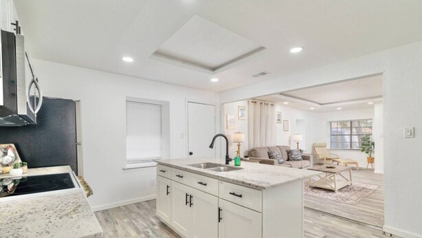 A modern kitchen with white cabinets, a granite countertop, and a built-in stove. - Downtown McAllen - Sleeps 10 (McAllen)