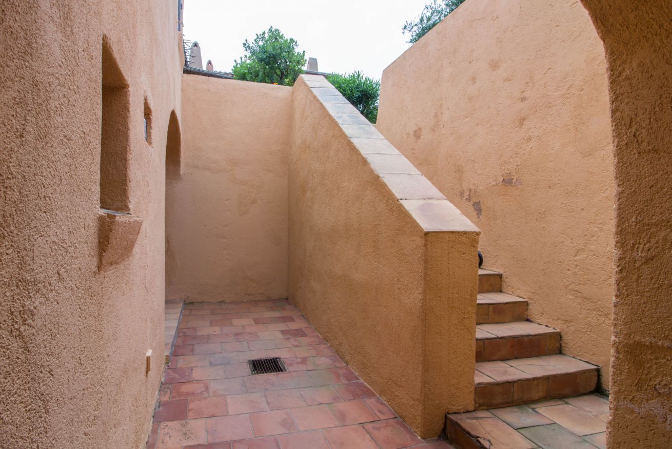 Un pasillo estrecho con una escalera que sube a un nivel superior.