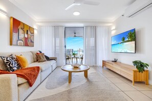 A modern living room with a sofa, coffee table, and TV.