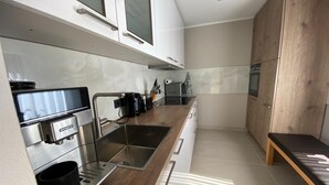 A modern kitchen with stainless steel appliances, wooden countertops, and a built-in oven. - Candel view (Waldkirch)