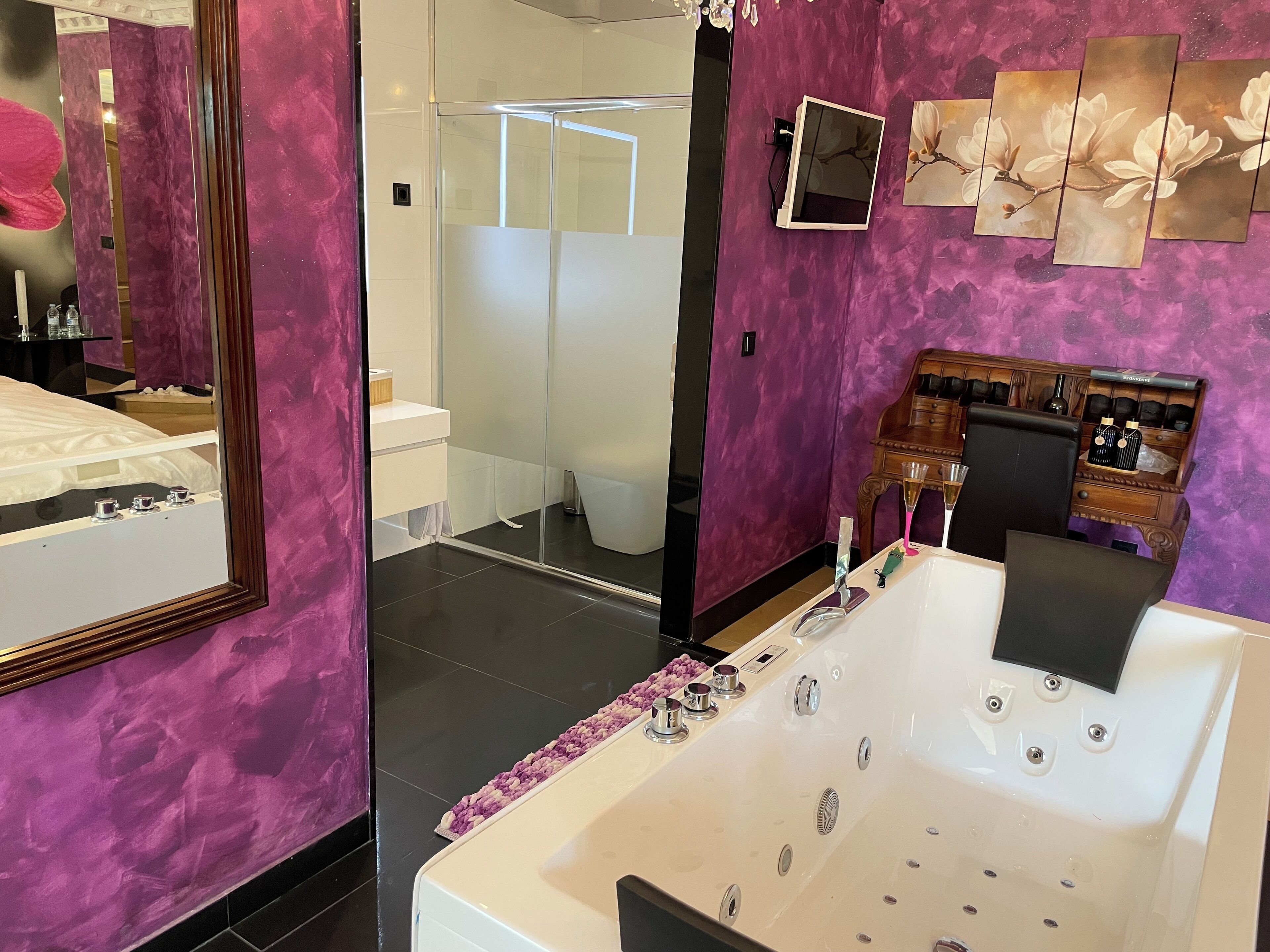 Un baño moderno con una bañera grande, un espejo y un tocador con lavabo.