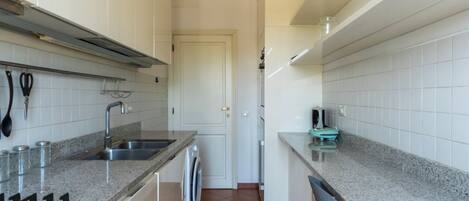 A kitchen with white cabinets, a stainless steel sink, a gas stove, and a dishwasher.
