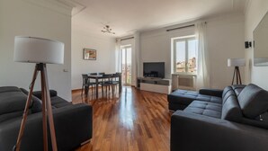 En moderne stue med en sofa, et spisebord og et fjernsyn.