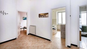 Un couloir avec un radiateur, un tableau et une vue sur une salle à manger.
