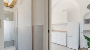 A modern kitchen with white cabinets, a wooden countertop, and a built-in oven. - GuestHost - MM2 Lambrate Bright Apartment (Milan)