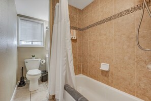 Un baño con inodoro, ducha y bañera.