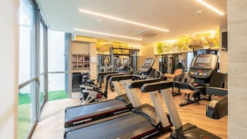 A gym with treadmills, elliptical machines, and weight equipment.