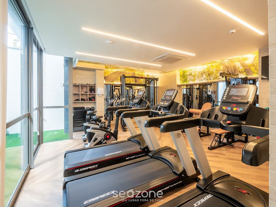 A gym with treadmills, elliptical machines, and weight equipment.