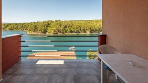 A balcony with a view of a lake and forest, a table, and a chair. - Cozy apartment in Krusevo with WiFi (Krusevo)