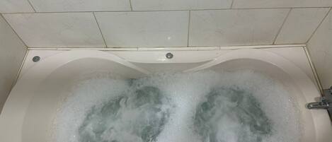 Chuveiro, banheira de hidromassagem, bidê, toalhas de banho