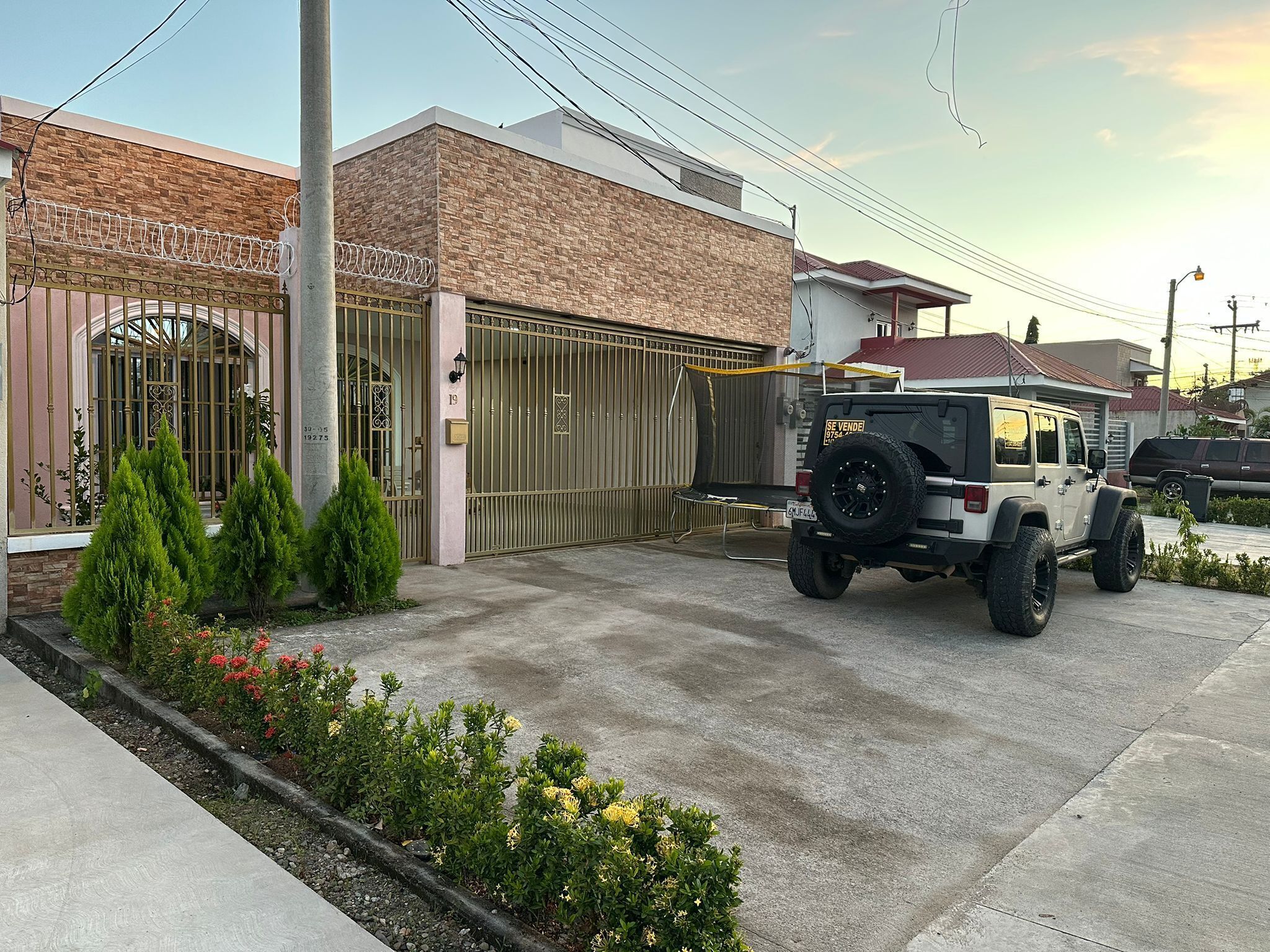 Uma entrada gradeada com um veículo estacionado em frente.