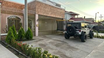 Uma entrada gradeada com um veículo estacionado em frente.