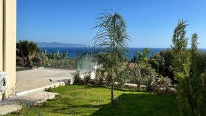 A residential property with a view of the ocean, a well-maintained lawn, and a variety of plants. - Luxurious Villa Retreat in Lourdata (Kefalonia)