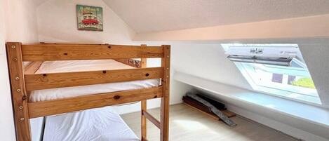 A small, single-bedded room with a sloped ceiling and a skylight.