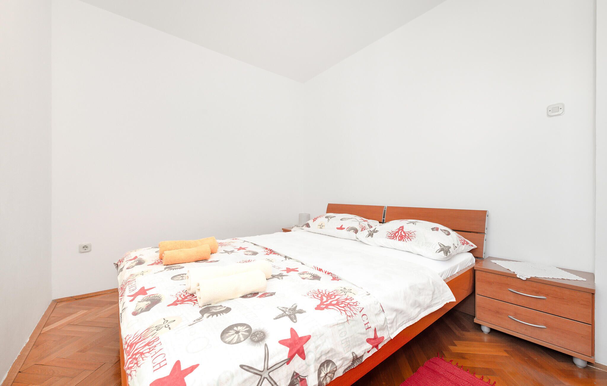 Une chambre à coucher avec un lit, une table de chevet et une commode.