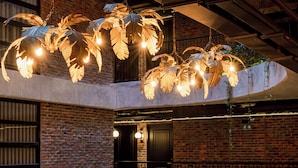 A modern interior with a brick wall, a curved railing, and a seating area with two chairs and a table. - The Host Medellin  (Medellín)