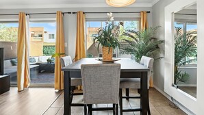 A dining area with a table, chairs, and a hanging light fixture. - Golf Course remodeled main floor condo in Old Town Scottsdale with King beds (Scottsdale)