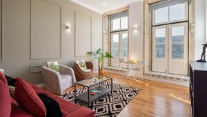 Ein geräumiges Wohnzimmer mit großem Fenster, einer Couch, einem Couchtisch und einem Essbereich.