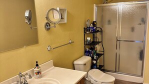 A bathroom with a sink, toilet, and shower.