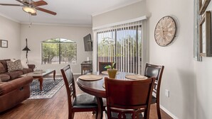 A dining area with a round table, chairs, and a potted plant.