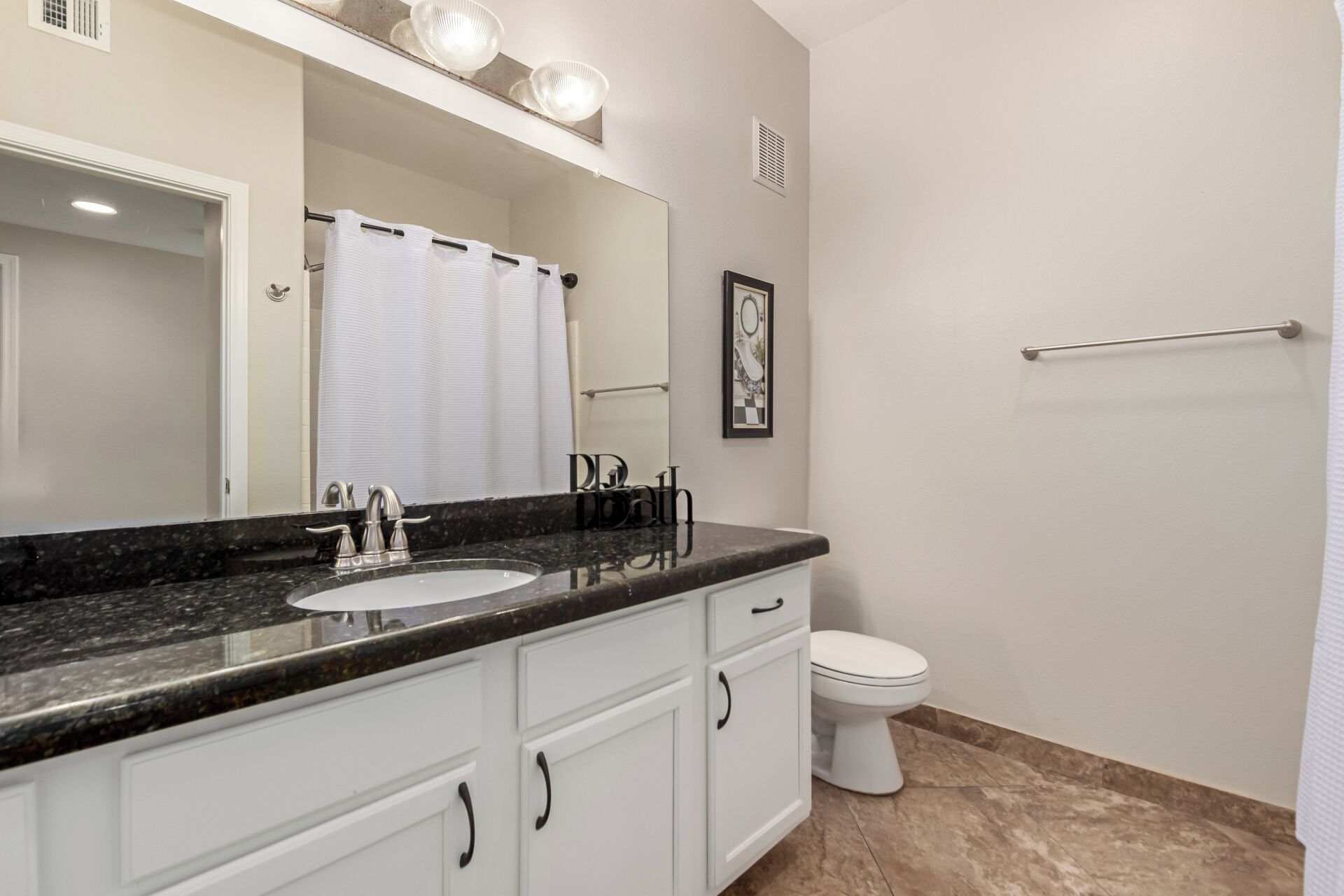 A bathroom with a sink, mirror, and toilet.
