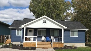 A two-story house with a front porch, a small deck, and a mailbox. - Algonac Harbour House (Algonac)