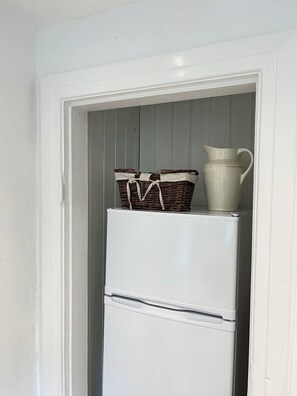 A white refrigerator with a wicker basket and a white pitcher on top. - Charming house with beautiful views (Gedser)