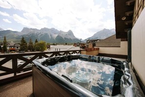 A hot tub on a balcony with a mountain view. - Sevenfold | Sleeps 20 | Luxe 7BR Retreat + Hot Tub (Canmore)