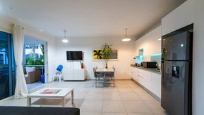 Um apartamento moderno com cozinha, sala de jantar e sala de estar.
