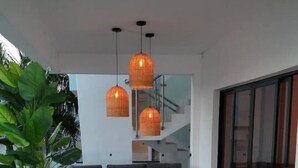 Un espace de vie extérieur moderne, comprenant un canapé, une table basse et des plantes en pot.