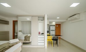 Una camera d'albergo con un letto, una scrivania, una sedia e angolo cottura.