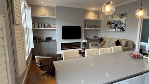 A modern kitchen with a large island, built-in appliances, and pendant lighting. - Luxurious Fulham Apartment (London)