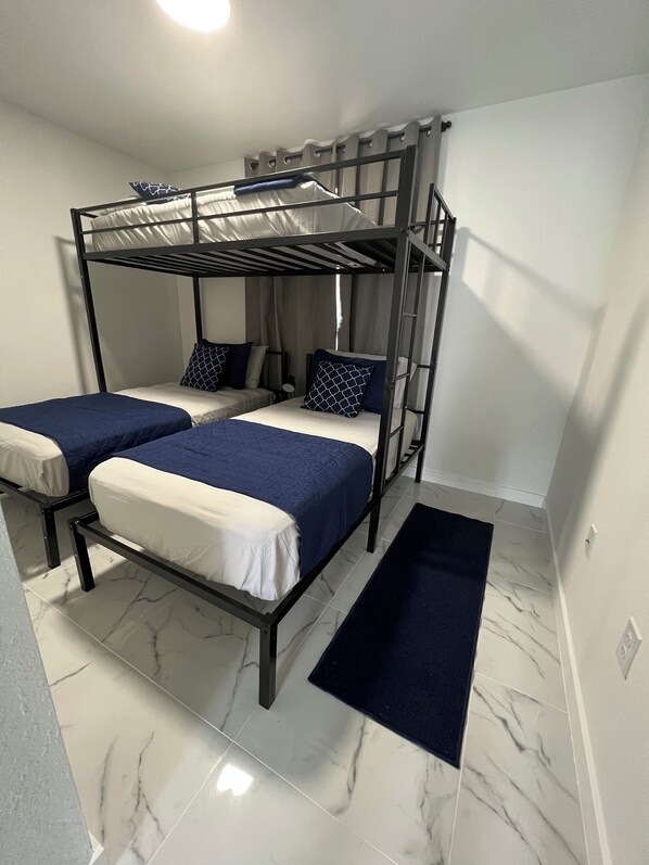 A bunk bed room with two beds, a small rug, and marble flooring. - 3BR, 3 BATH house NEW JACUZZI. SLEEPS 11 (Miami)