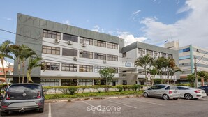 A modern building with multiple floors, air conditioning units, and a parking lot with several cars. - Comfortable Apartment, Lago Norte Bvt0418 (Lago Norte)