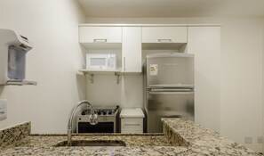 A compact kitchenette with a microwave, a stainless steel refrigerator, a gas stove, and a sink. - Comfortable Apartment, Lago Norte Bvt0418 (Lago Norte)
