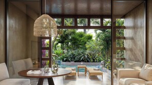 A modern living room with a round table, two sofas, and a view of a swimming pool and tropical plants. - The Westin Playa Vallarta, An All-Inclusive Resort (Puerto Vallarta)
