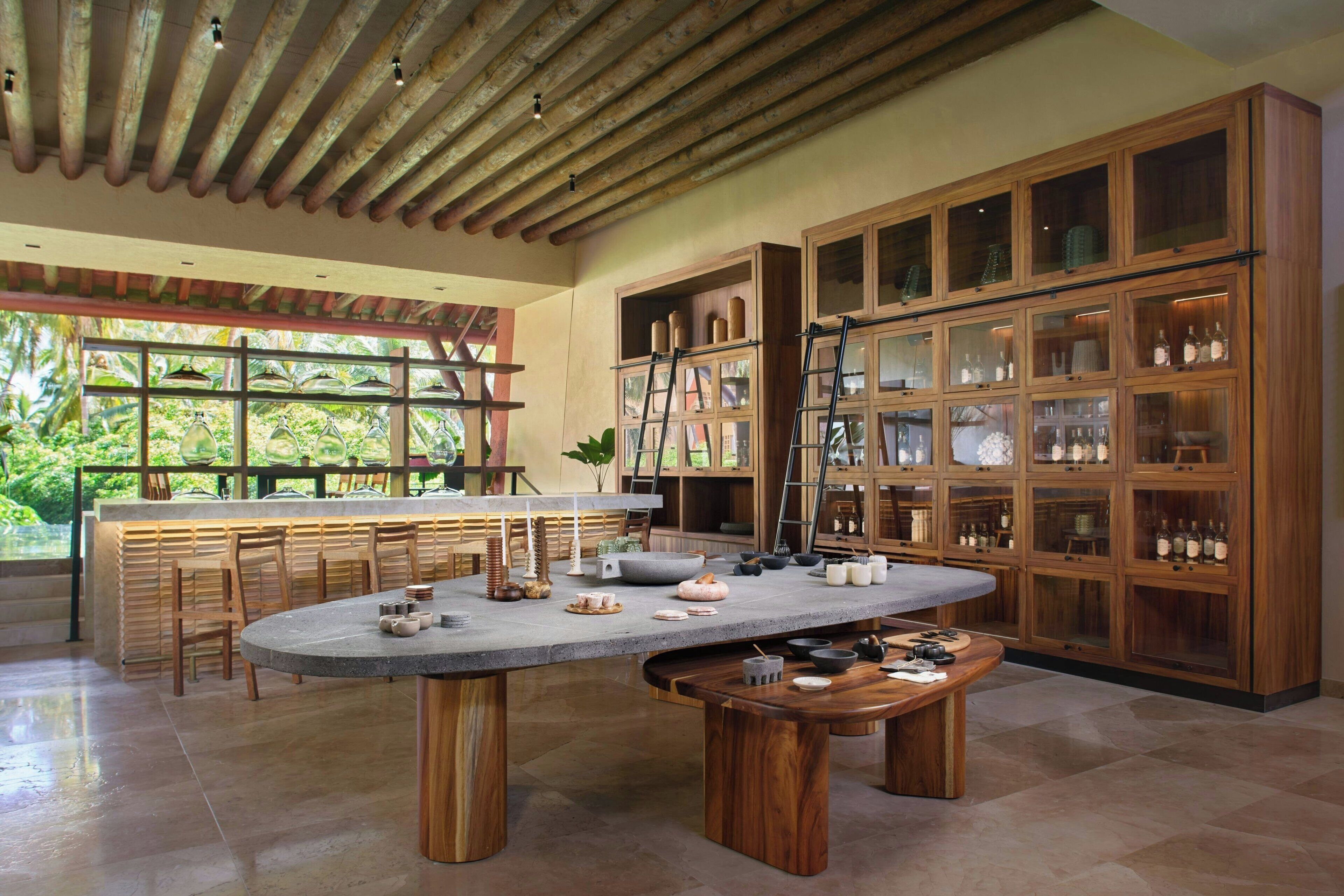 A spacious kitchen with a large island, wooden cabinets, and a view of greenery outside.