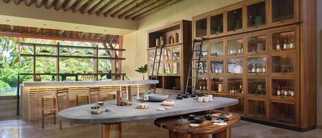 A spacious kitchen with a large island, wooden cabinets, and a view of greenery outside.