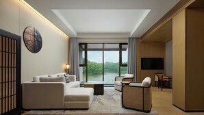 A modern living room with a sofa, armchairs, a coffee table, and a TV. -  长兴开元名都臻品之选度假酒店 (Huzhou)